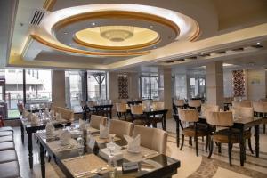 拉斯阿尔卡麦Ras Al Khaimah Hotel的一间带桌椅和大型天花板的餐厅
