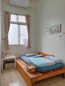 嘉义市拉瓦宅 輕旅店 - Lawa House的一间卧室配有一张木床和窗户