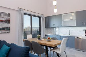 干尼亚Aurora apartments的厨房以及带木桌和椅子的用餐室。
