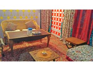 斯利那加Blue heaven House boat, Srinagar的客厅配有桌子和床。
