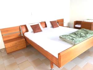 科纳克里Résidences MAFCA的一间卧室配有一张带白色床单的木床