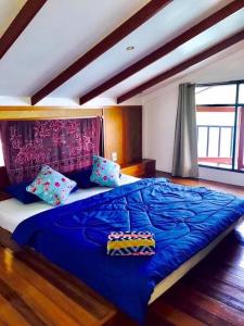 象岛Koi Seahouse的卧室内的一张大床,配有蓝色床单和枕头
