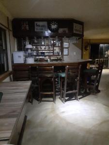 KomgaNgwenkala Game Lodge and Safaris的厨房配有带椅子和柜台的酒吧