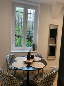 第戎Appartement chaleureux的一个带两扇窗户的房间,配有一张桌子和椅子