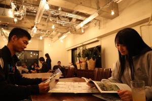 松本Guest House Ichiyama Shukuba的坐在一张桌子旁看地图的男人和女人