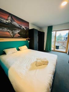 莱德萨阿尔卑斯The People - Les 2 Alpes的一间卧室配有一张大床,上面有毛巾