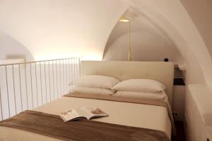 圣雷莫kaDevi piazza Bresca - pieno centro, parcheggio, bici的一间卧室配有一张床,上面有一本书