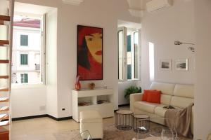 圣雷莫kaDevi piazza Bresca - pieno centro, parcheggio, bici的客厅配有沙发和墙上的绘画