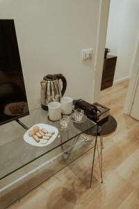 巴勒莫Four Luxury Suite的茶壶和一盘甜甜圈的玻璃桌