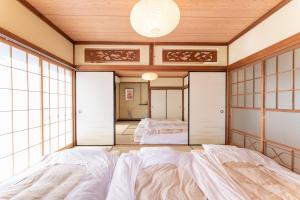 箱根樹蘭蕉 箱根仙石原 - JYURANSHO Hakonesengokuhara的一间日式卧室,配有两张床和一面镜子