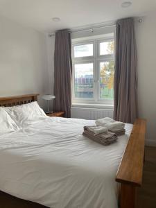 WansteadFamily friendly new flat at London Gants Hill Station near Ilford的卧室配有白色的床和窗户