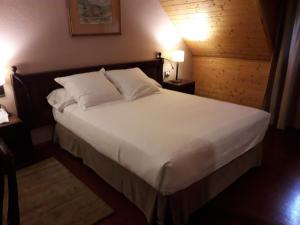 阿蒂斯阿蒂斯旅馆的卧室配有一张带白色床单和枕头的大床。