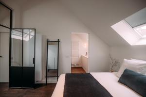 安特卫普Sud d'Anvers的白色卧室设有床和天窗