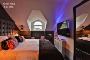 鲍内斯温德米尔The Rockefeller Apartments的一间卧室设有一张大床,拥有紫色的天花板