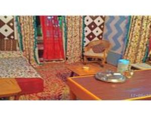斯利那加Blue heaven House boat, Srinagar的一间设有两张床、一张桌子和一把椅子的房间