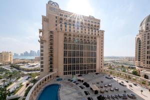 多哈Al Gassar Resort的享有带游泳池的大型建筑的景致。