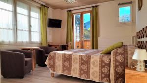 韦尔科尔地区拉沙佩勒贝利尔酒店的一间卧室配有一张床、椅子和窗户。