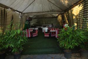 安加马尔伊Airport Cochin Grand Residency , NEDUMBASSERY的餐厅设有红色的桌椅,背景人员