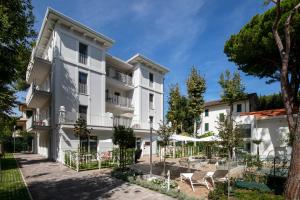 里乔内Elegance Riccione的享有白色公寓大楼外景,设有庭院