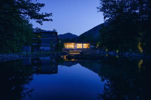 JozankeiOkujozankei Onsen Kasho Gyoen的夜晚坐在河边的房子