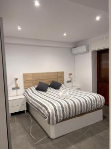 科尔多瓦Apartamento espacioso de diseño a 3 min RENFE.的白色卧室配有带条纹棉被的床