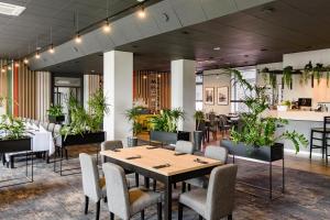 波兹南IOR酒店的一间设有桌椅和植物的餐厅