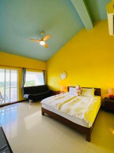 恒春古城垦丁卡米克特色民宿的一间卧室设有一张床和黄色的墙壁