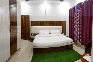 ChariHeavenly Holiday Villa - with parking的卧室配有白色的床和紫色窗帘