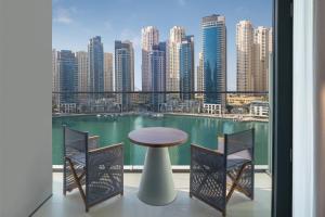 迪拜迪拜码头及游艇俱乐部葳达酒店的市景阳台配有桌椅。