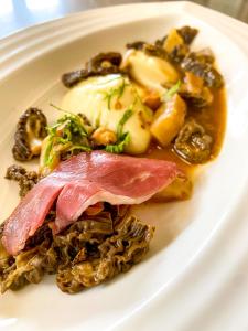 沙托纳城堡酒店的肉和蘑菇的白盘食物