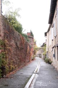 雷克图尔Gîte le petit écolier的一条空的街道,靠近石墙