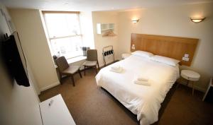 波特里The Caledonian的卧室设有一张白色大床和一扇窗户。