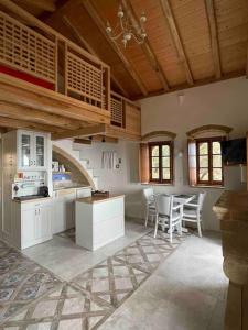 莫奈姆瓦夏MONOVASIA SUITES Anopolis的厨房配有白色橱柜和桌椅