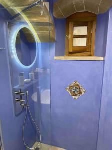 莫奈姆瓦夏MONOVASIA SUITES Anopolis的蓝色的浴室设有淋浴和镜子