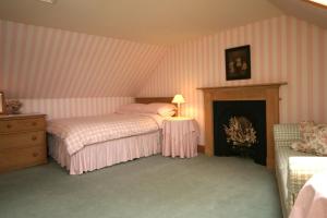 StrachurSpringburn Cottage的一间卧室设有两张床和一个壁炉