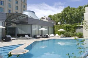 门多萨门多萨莫德酒店的一座带椅子的游泳池以及一座建筑