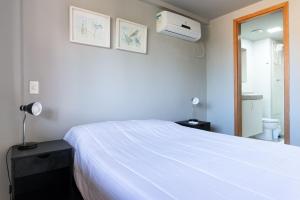 嘎林海斯港Praia Central Porto de Galinhas的一间带白色床的卧室和一间浴室