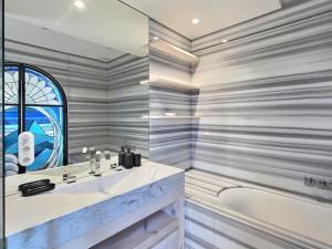 圣让-德吕兹RESIDENCE HARCOURT SAINT-JEAN-DE-LUZ的浴室配有盥洗盆和浴缸。