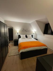 奥内姆Le 6B的一间卧室配有一张带橙色毯子的大床