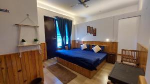 比尔瓦The Hostel Stories, Bir - Landing Site的一间卧室设有蓝色的床和窗户。