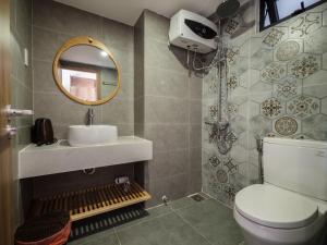 岘港Wings House的一间带卫生间、水槽和镜子的浴室