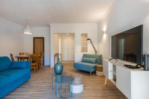 吉亚Salgados 1 Bedroom Apartment - 500m from the Beach的客厅配有蓝色的沙发和电视