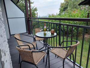 卡尔帕奇Apartament Pod Papugami 2 Karpatia Resort的阳台上配有一张桌子、两把椅子和两瓶葡萄酒