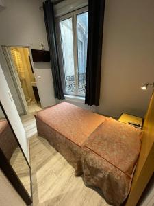 蒙彼利埃德拉柯美迪酒店的一间卧室设有一张床和一个窗口