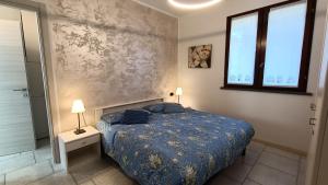 多马索House in a beautiful residence with garden, swimming pool and parking spot - Larihome A07的一间卧室设有蓝色的床和窗户。