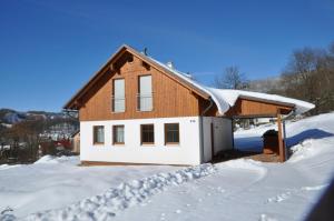 切尔尼杜尔Chalupa pod vrškem的积雪覆盖的房屋