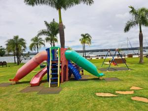 巴西利亚Life Resort Flat - Torre F - Beira do lago的棕榈树公园内一个带滑梯的游乐场