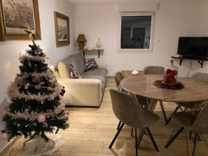 克松吕-隆日梅Les écureuils的客厅配有圣诞树和桌子