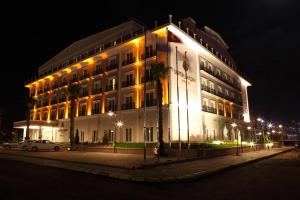 科贾埃利卢克索花园酒店的一座白色的大建筑,晚上有灯
