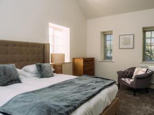 克利夫罗The Groomsmen的一间卧室配有一张床、一把椅子和窗户。